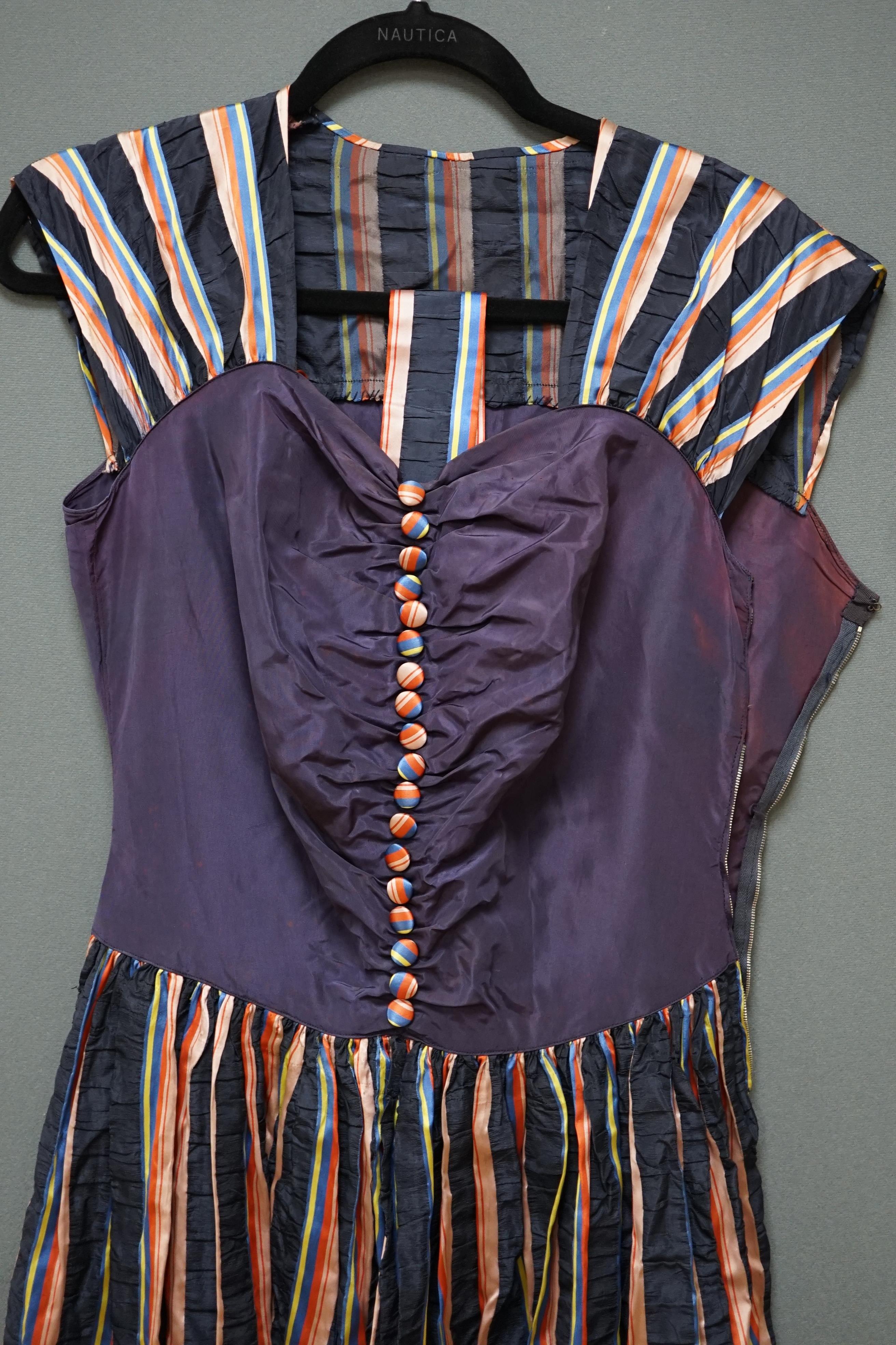 A 1940’s multi coloured striped silk and taffeta evening dress, designed with a blue taffeta bodice and colourful stripe gathered skirt, belt and back strapped yoke and matching buttons, 43cm front chest arm to arm. Cond